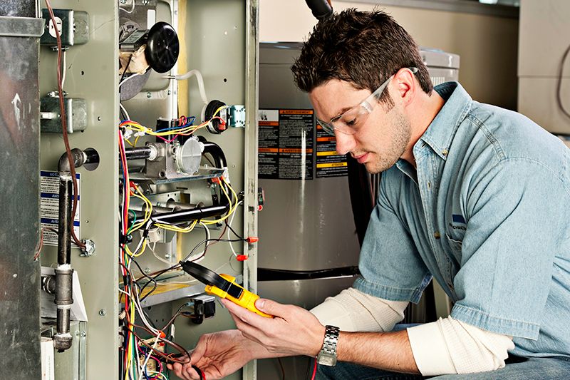 Image of technician working on ac unit. Why Do I Need AC Maintenance Now.