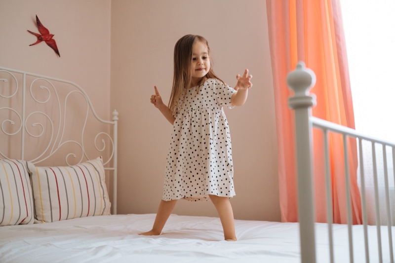 What You Should Know About Air Handlers. Happy funny little child girl in motion jumping on bed alone flying in air feeling joy, cheerful cute active kid having fun playing laughing in bedroom after waking up, good morning children concept.