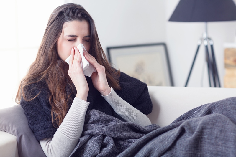 Woman Blowing Her Nose and Dealing with Allergies.